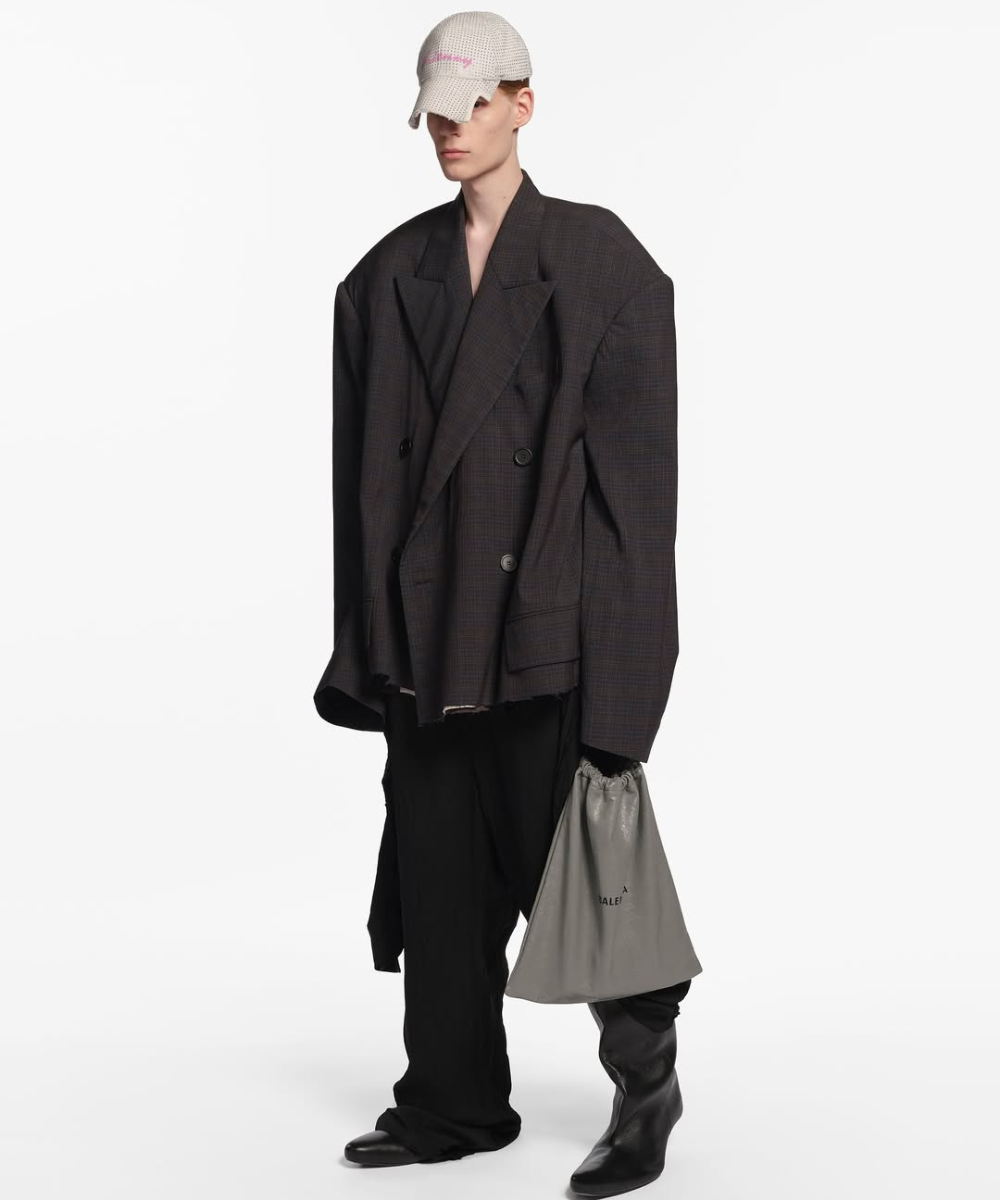 Pessoa veste Balenciaga com blazer oversized e boné.