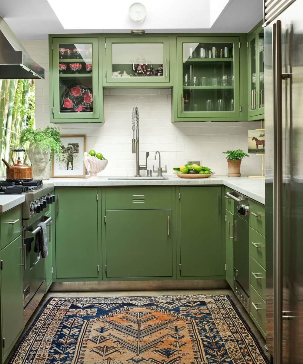 Cozinha elegante com armários verdes e decoração sofisticada na casa da Dakota Johnson.