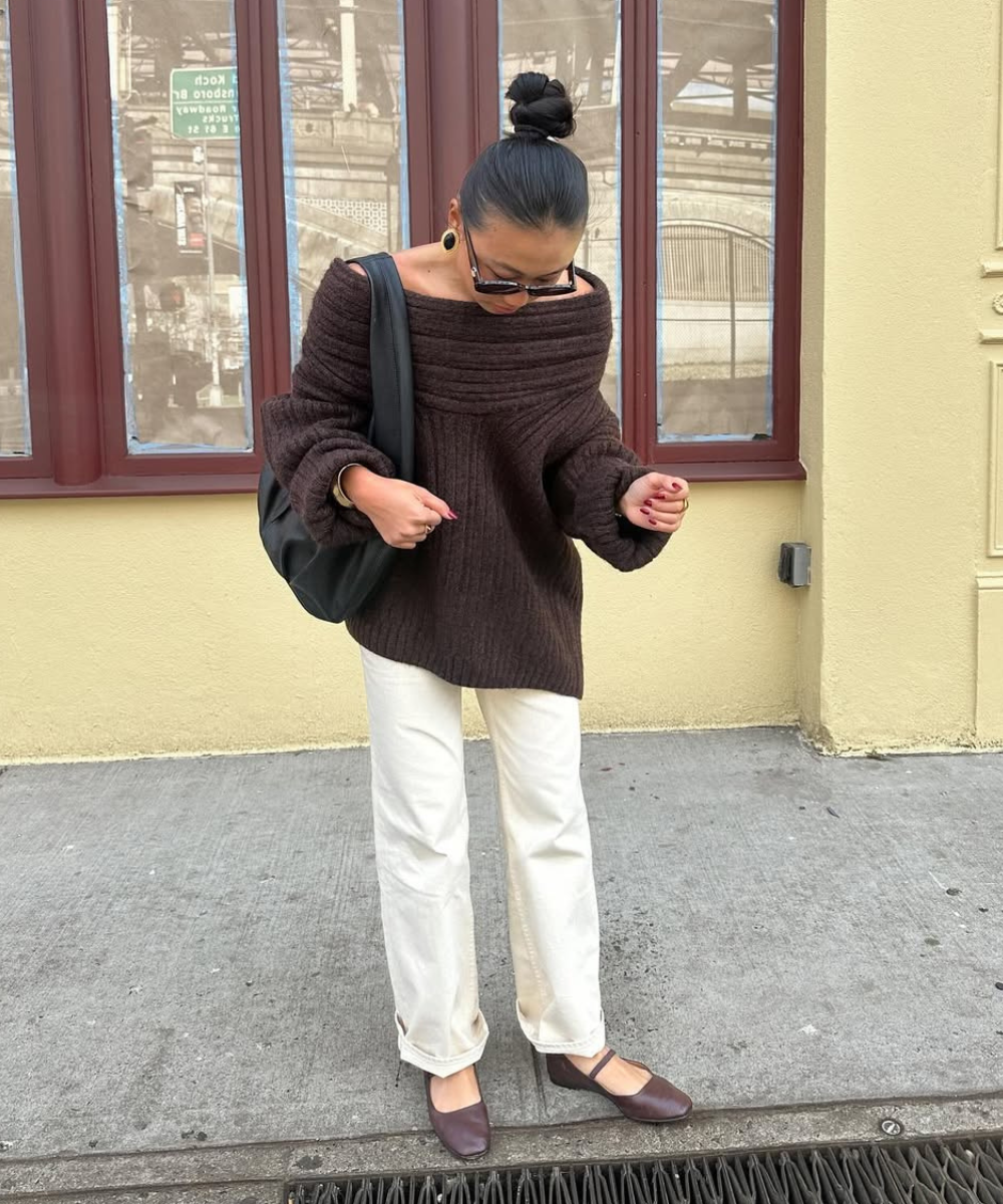Suéter marrom com calça clara e sapatos combinando em tom marrom, bolsa preta e cabelos presos.