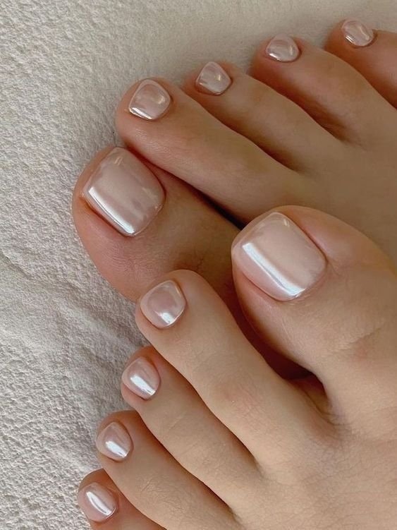Unhas dos pés com esmalte em tom perolado, destacando a sutileza nas cores de esmalte para os pés.