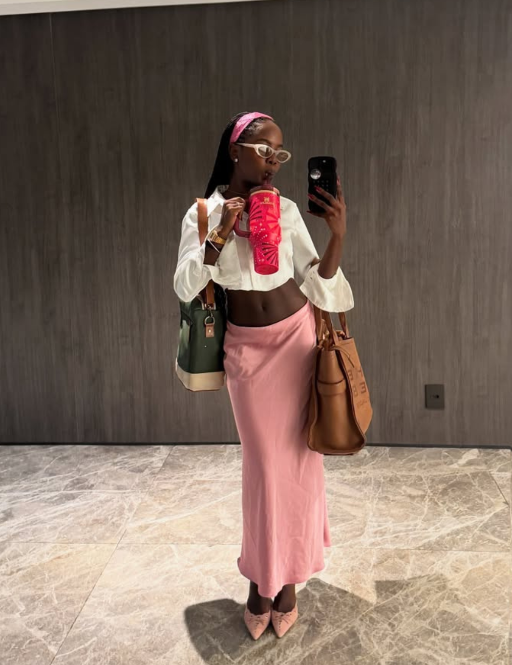 Pessoa elegante em selfie no espelho, vestindo saia rosa e blusa branca.
