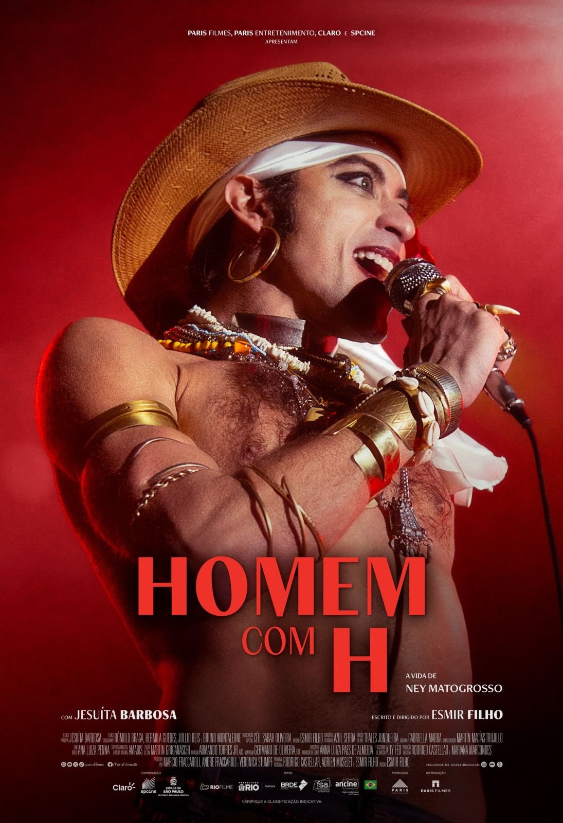 Cantor performático com chapéu e microfone no palco. Filme biográfico brasileiro sobre música e identidade.