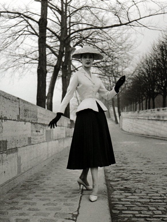 Elegante modelo em roupa clássica, com chapéu e luvas, reflete moda de luxo em cenário de inverno.