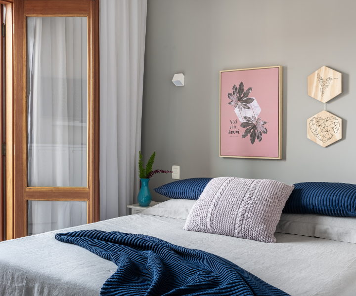 Quarto moderno com paredes cinza, possível inspiração para pintar a casa, cama cinza e decoração elegante.