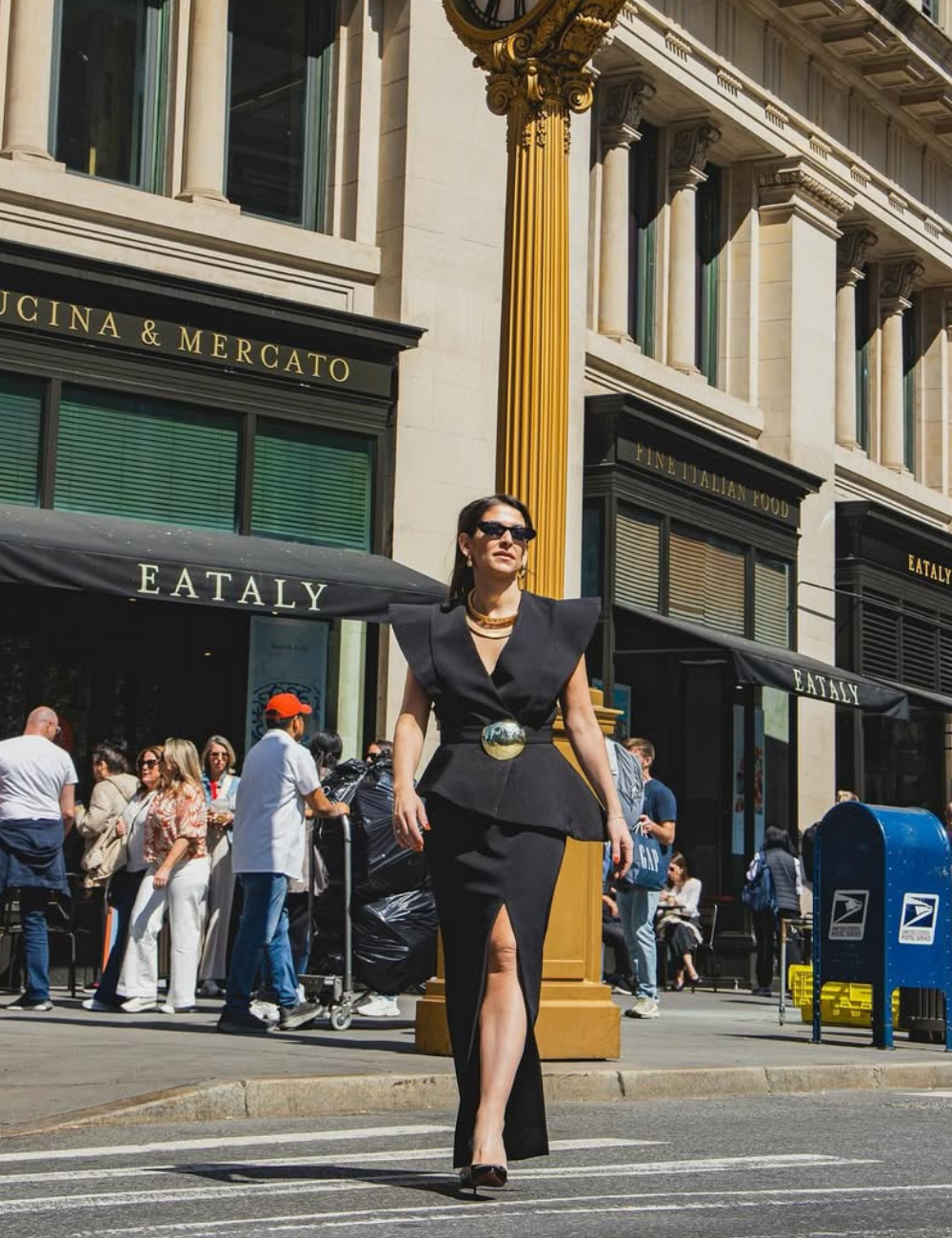 Mulher em traje elegante, simbolizando Power Dressing, caminha confiante em rua da cidade.
