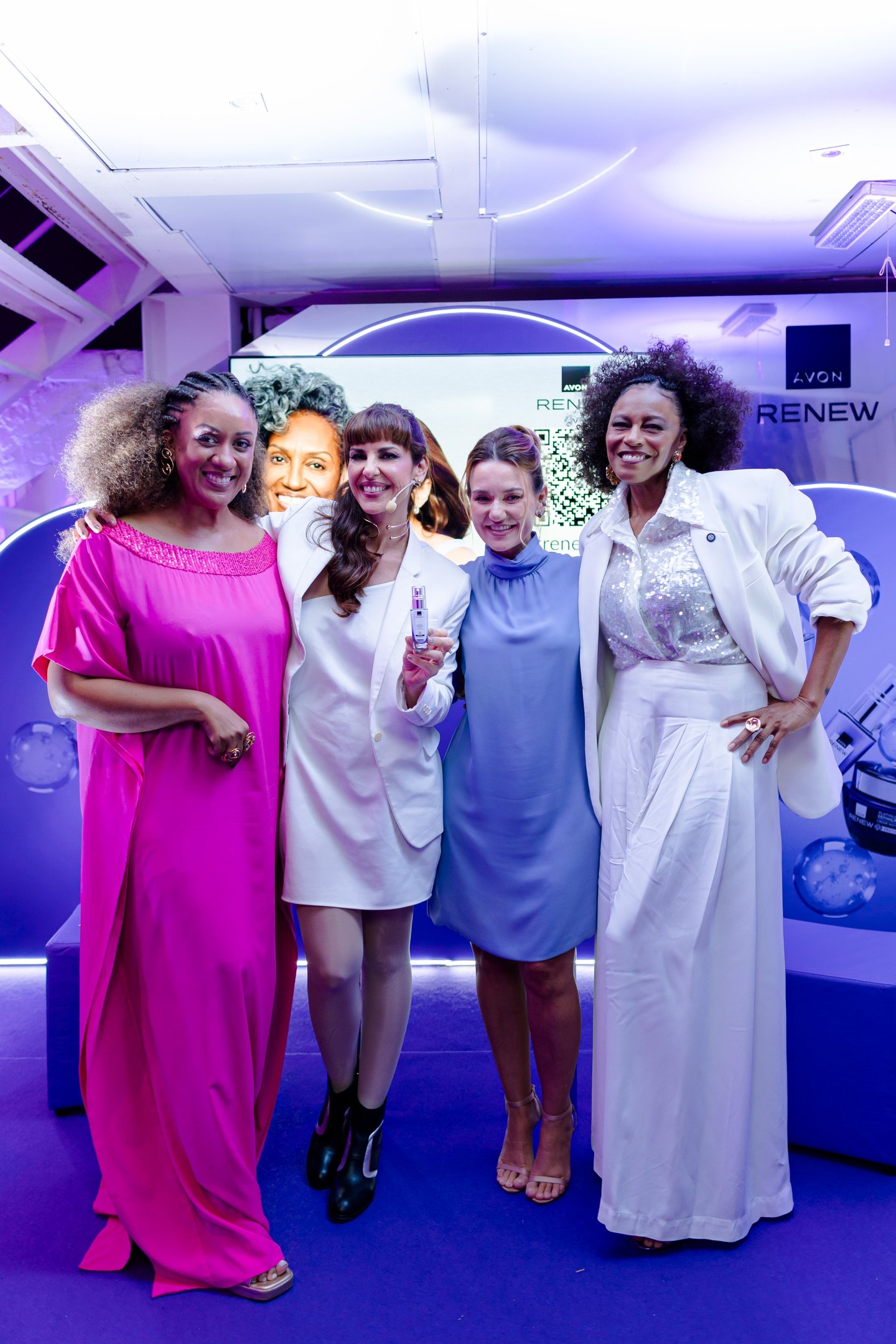 Quatro mulheres sorrindo em um evento da Avon, com foco no produto Renew Lift em destaque.