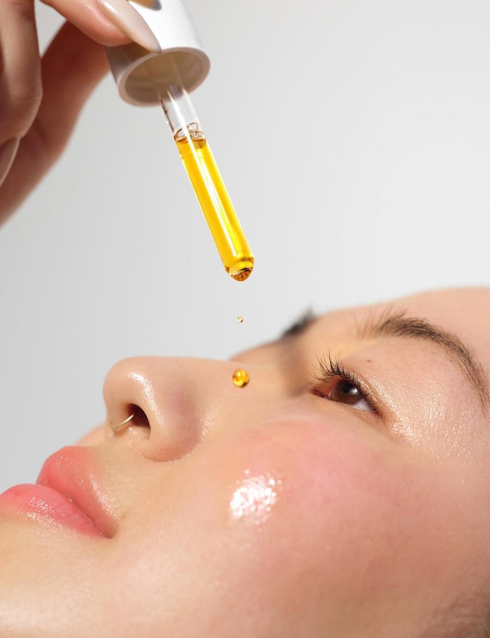 modelo aplica óleo facial