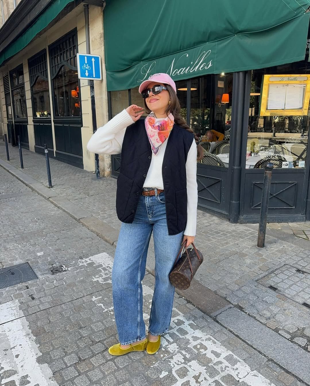 influenciadora usando calça jeans, blusa de manga longa branca e colete, peças básicas de inverno