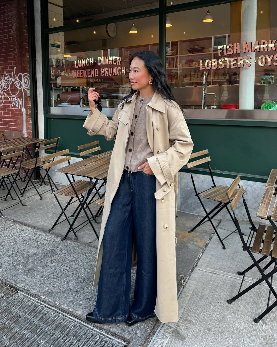 influenciadora usando look de calça jeans, trench coat e trico, uma ótima inspiração para usar com smartwatch
