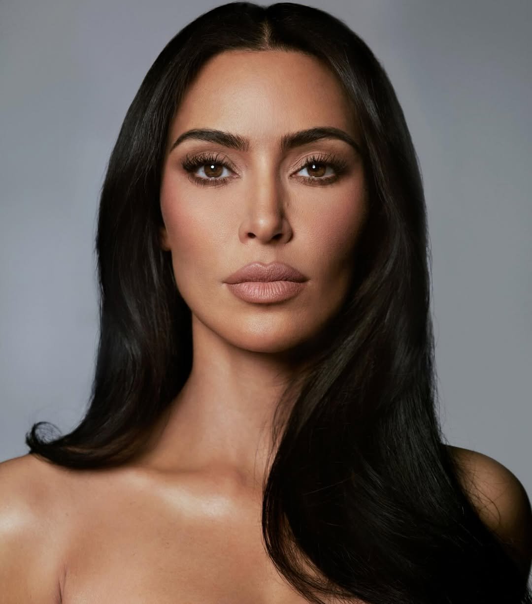 Celebridade com maquiagem impecável, batom nude e sombras destacadas, realçando os olhos. Reportando a tendência de maquiagem da Kim Kardashian