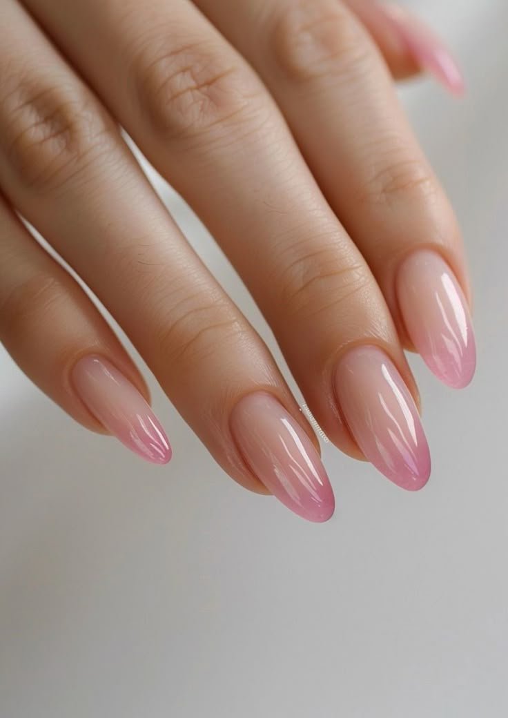 Unha amendoada e esmalte rosa claro com brilho.