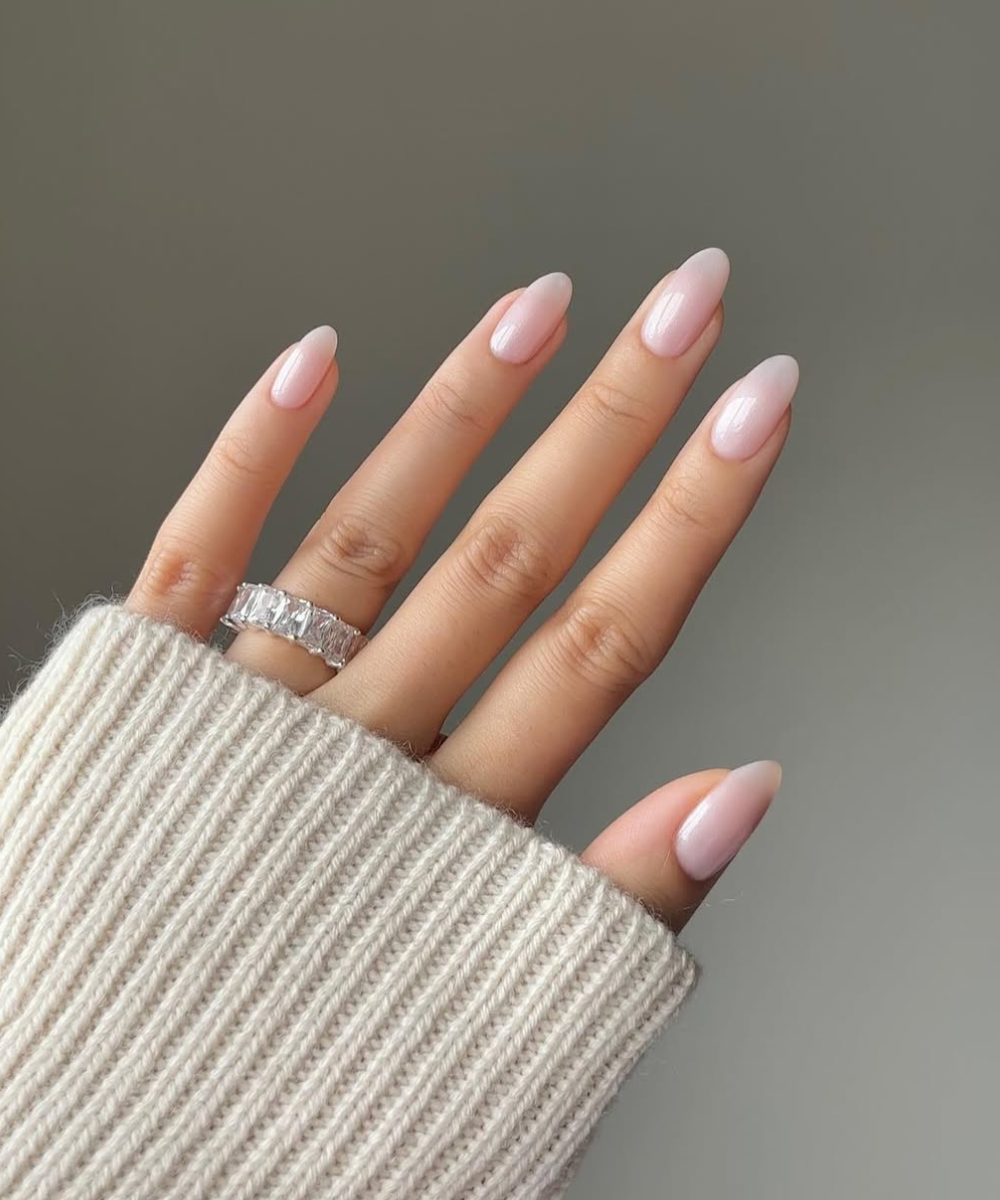 Unhas bem cuidadas com esmalte rosa-claro, ideias charmosas de cores de unha para noivas, mão com anel brilhante.