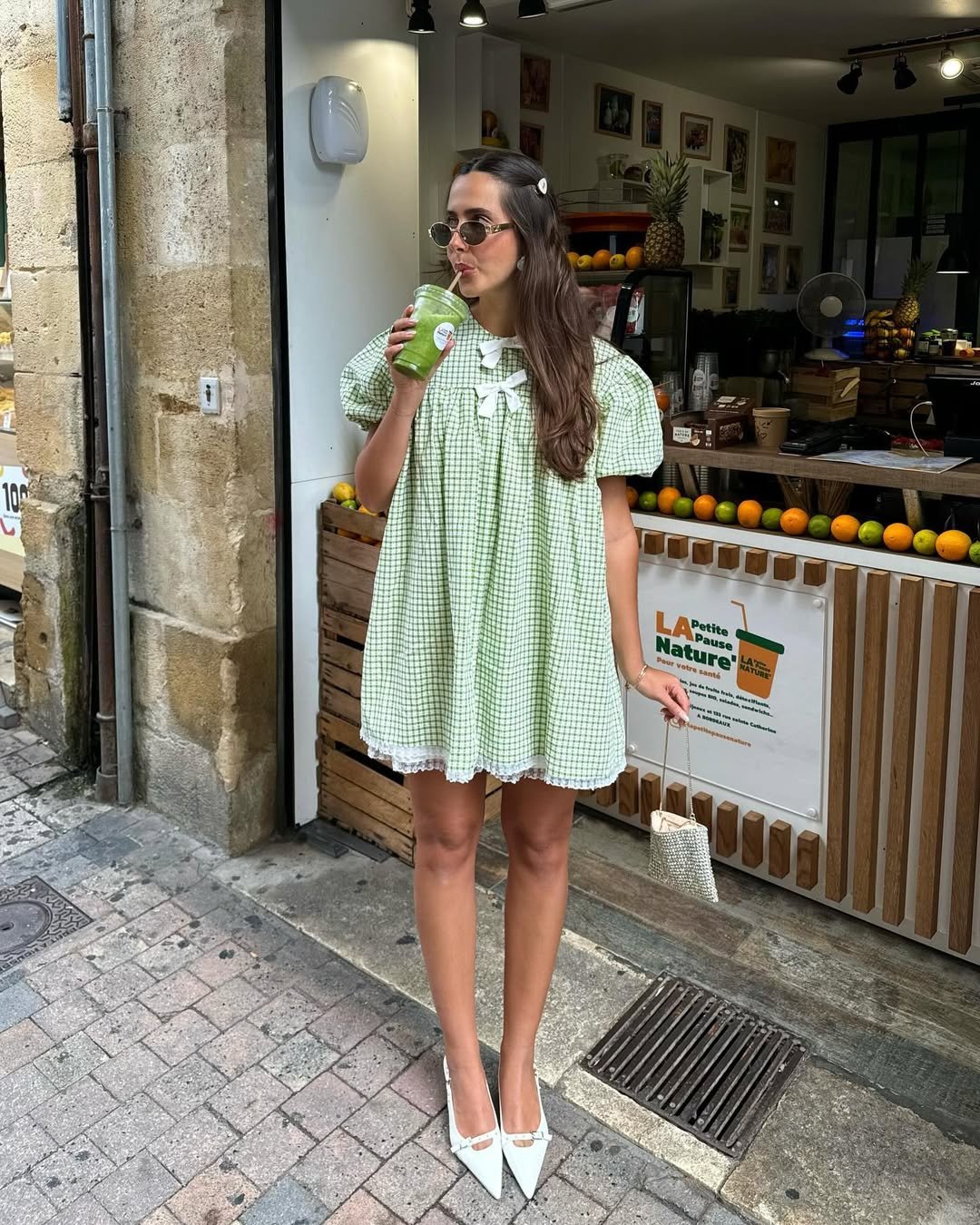 Vestido xadrez verde com babados, ideal para festas juninas. Mulher toma suco verde na rua.