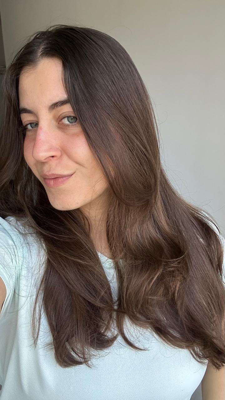 mulher posando com blusa verde e cabelo liso antes do uso da linha liso dos sonhoos de elseve