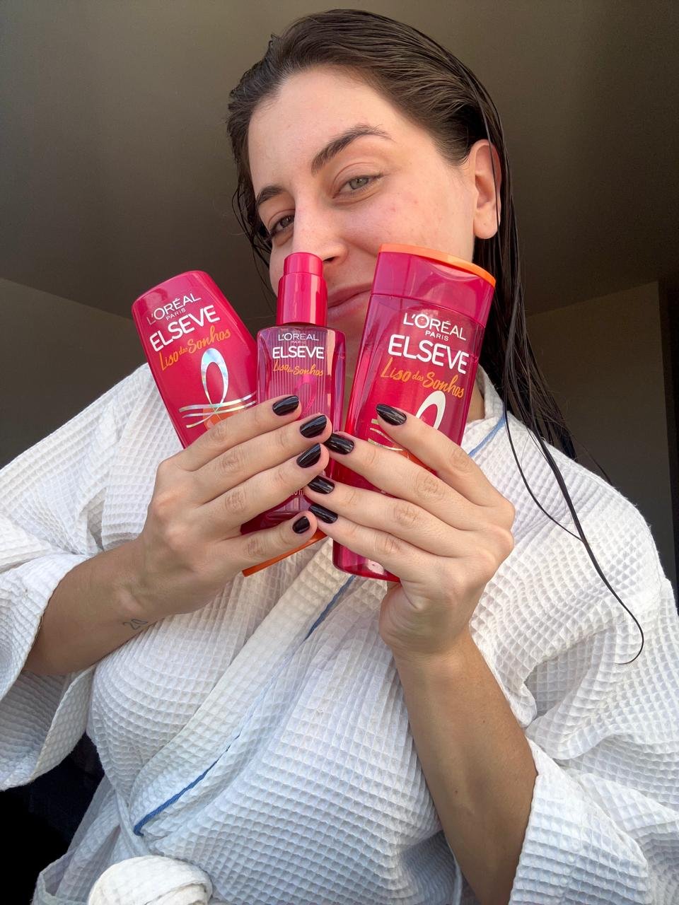 mulher posando de roupão com os produtos da linha liso dos sonhos de elseve