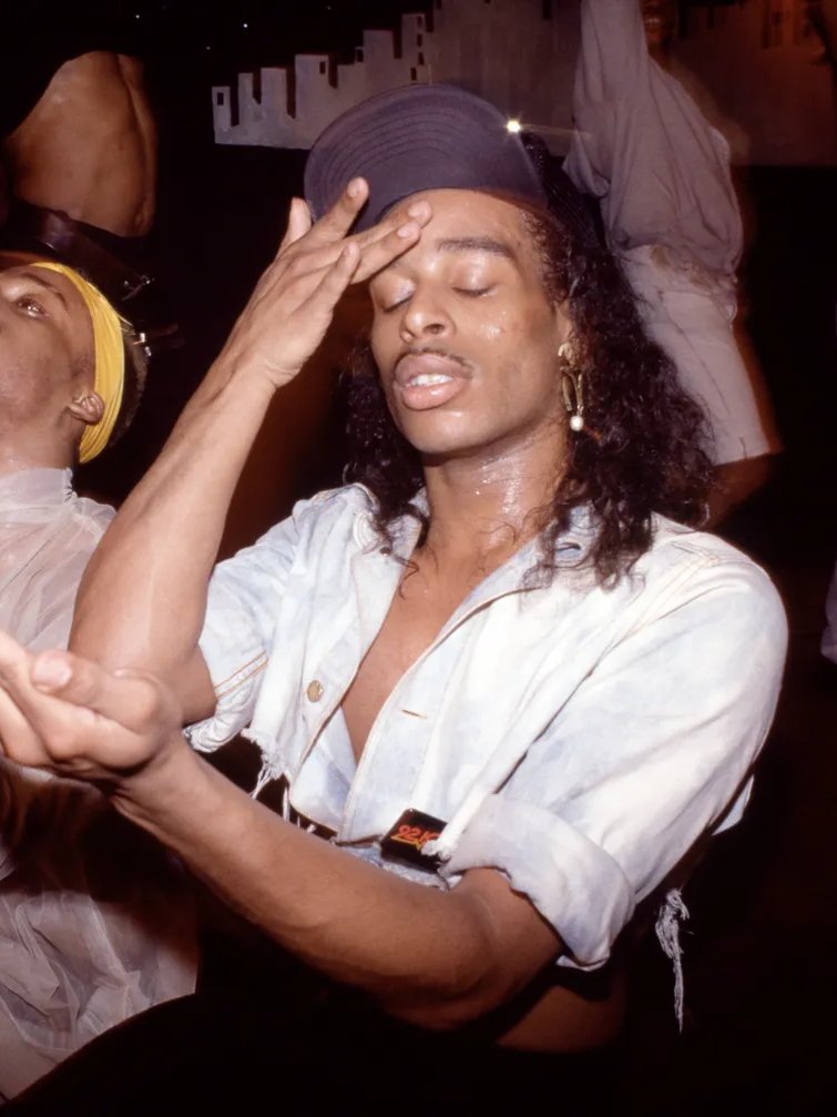 Pessoa dançando em ambiente vibrante, com expressão de concentração. O evento destaca cultura e diversidade LGBTQIAPN+.