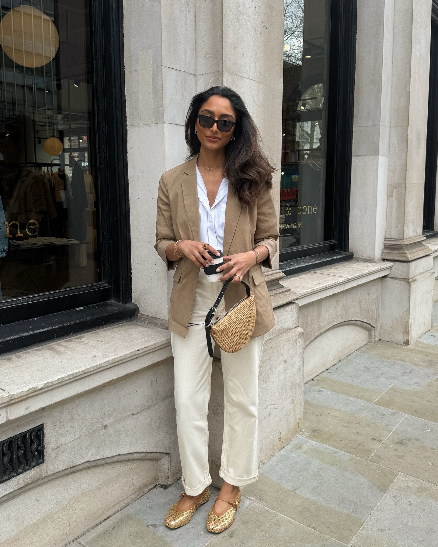 Pessoa usa um blazer cáqui, camisa branca e calça clara. Look ideal para entrevista.