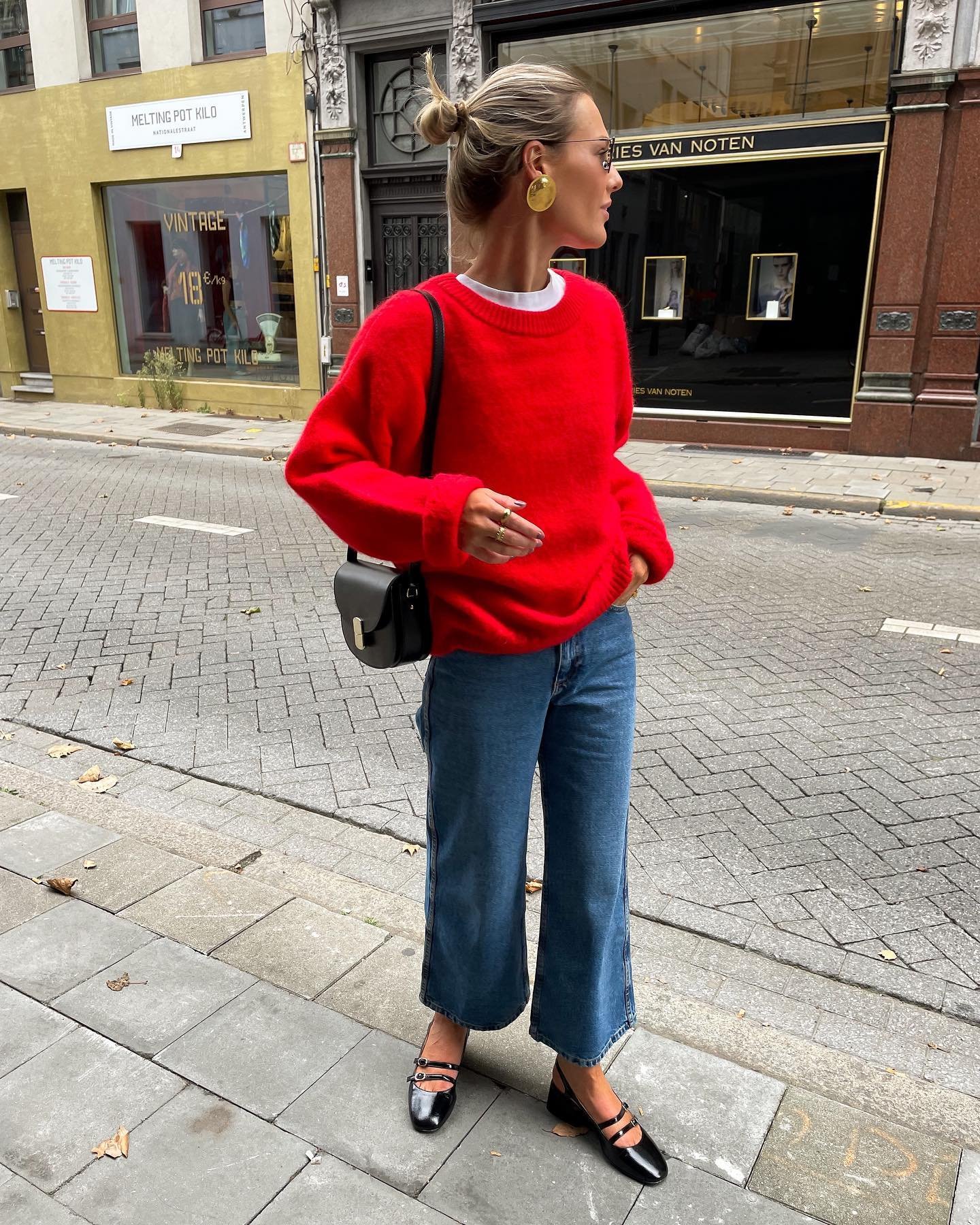 Pessoa em look casual com suéter vermelho e jeans, ideal para contextos descontraídos.