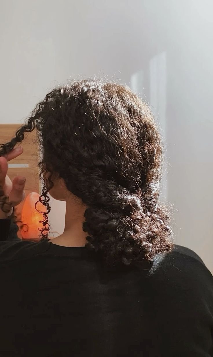 Cabelos cacheados soltos e volumosos em penteado sem tração.