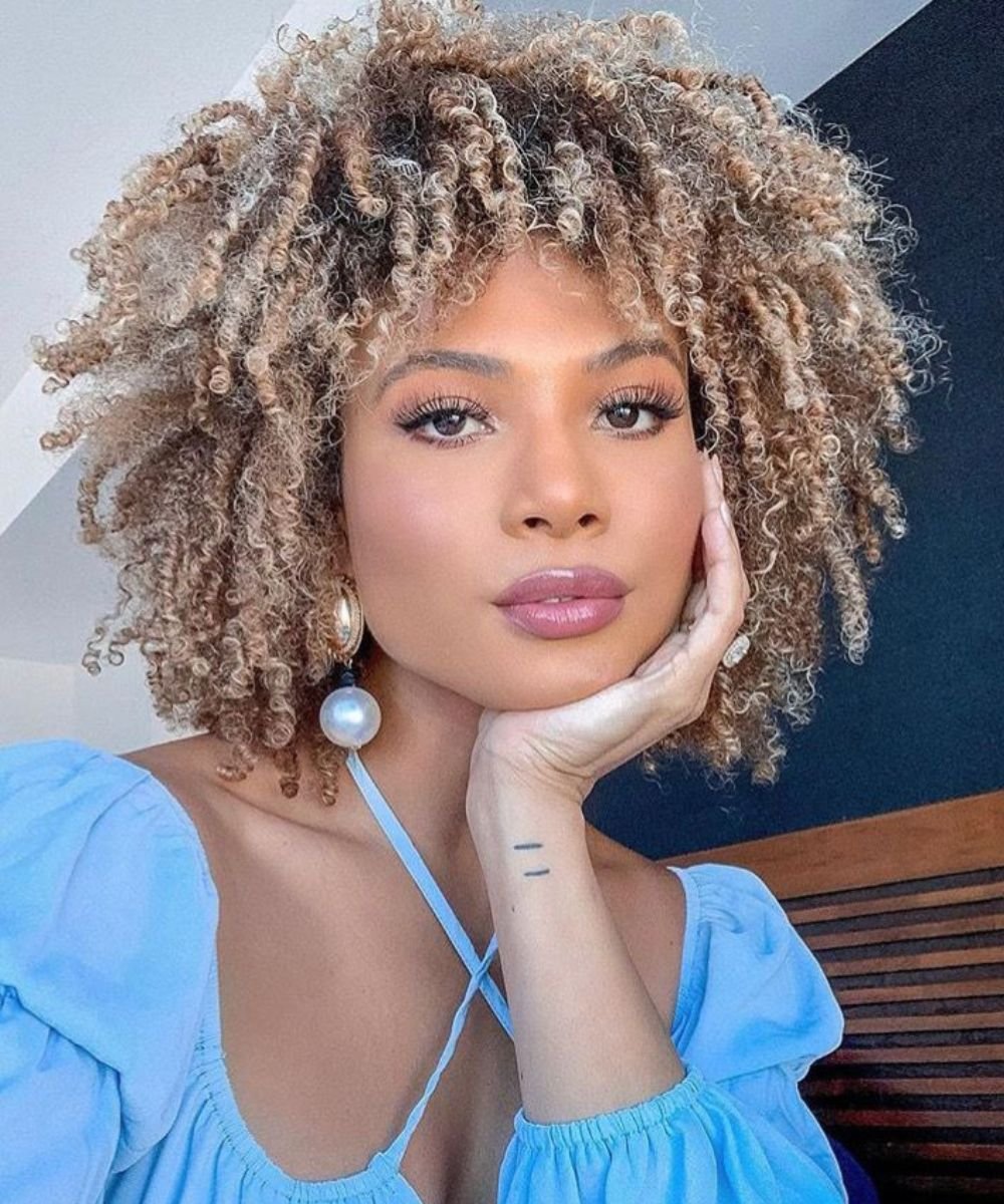 Cabelo crespo loiro em estilo volumoso e natural, mostrando um exemplo de cuidado dentro de um cronograma capilar.