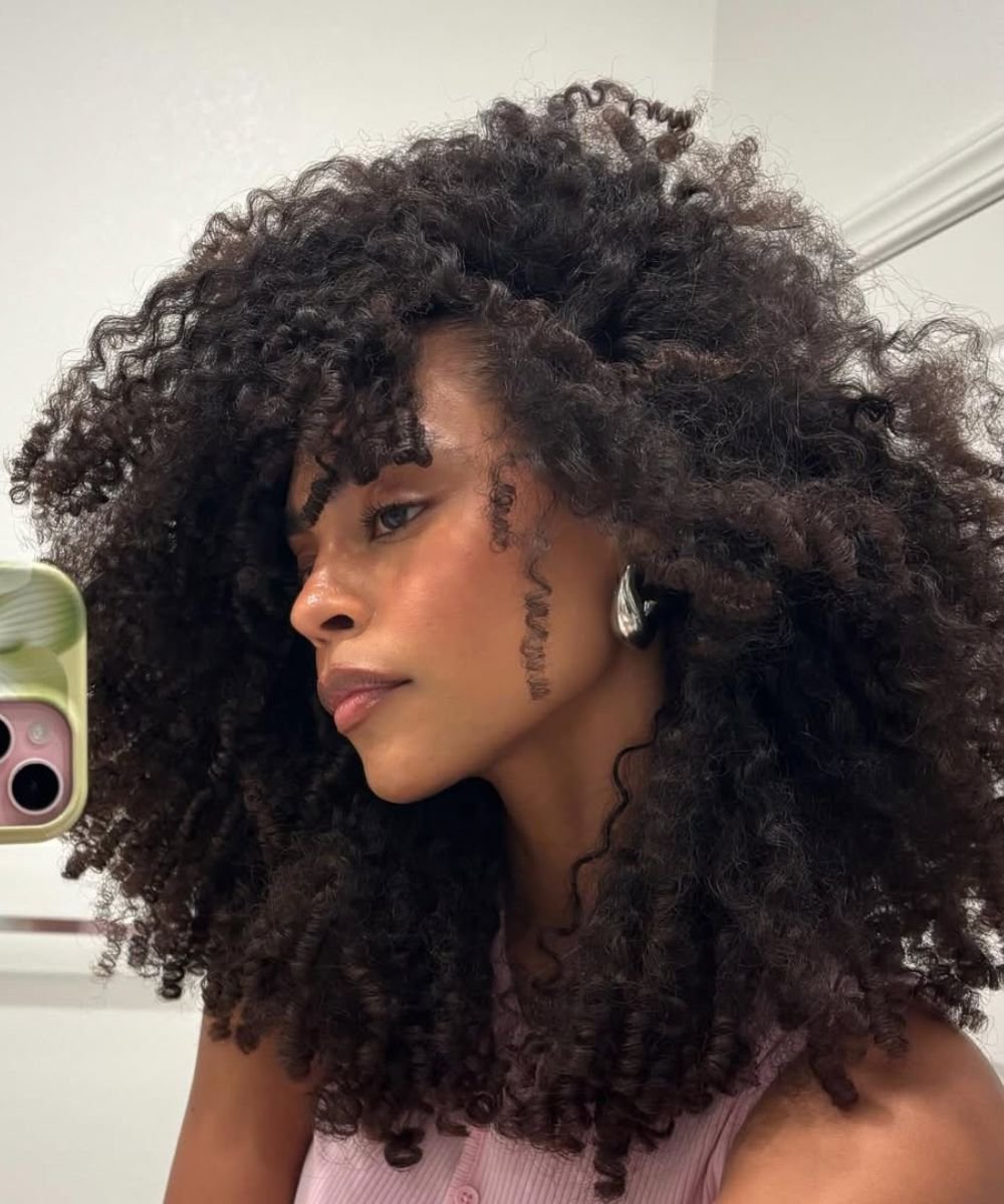 Cabelo cacheado volumoso e bem definido, estilo day after, em destaque.