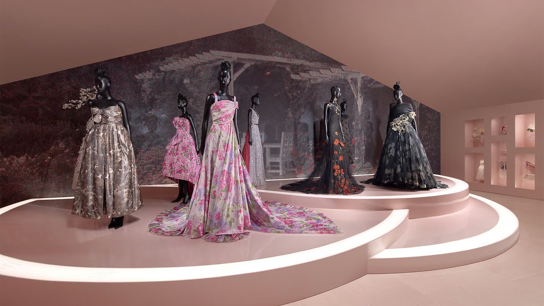 Manequins exibindo vestidos de gala florais em um luxuoso display, evocando Christian Dior Jardins Rêves.
