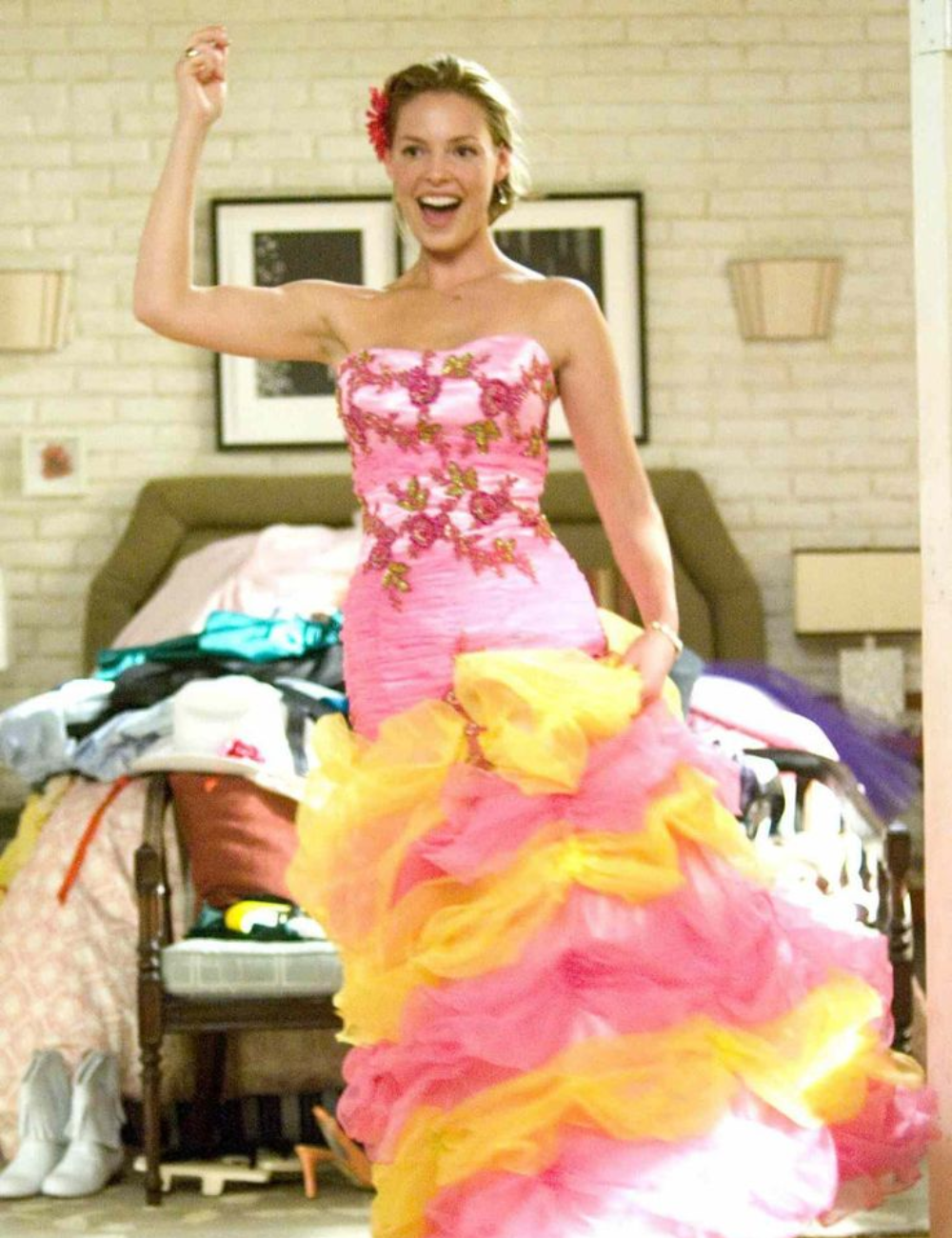 Pessoa com vestido colorido vibrante, sorrindo animadamente, em cena típica de comédias românticas.