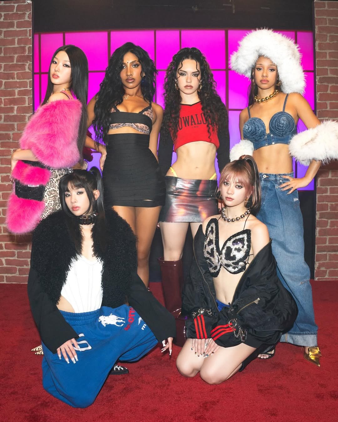 Pessoas posam com roupas elegantes e coloridas em um tapete vermelho, refletindo o estilo katseye.