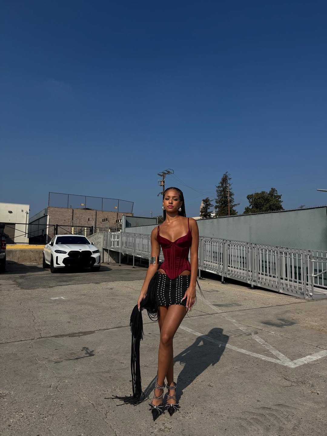 mulher em roupa estilosa com fundo urbano e céu azul. Katseye