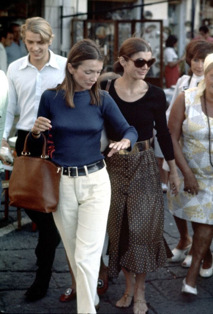 Lee Radziwill caminhando em uma rua movimentada, usando roupas casuais. A palavra-chave especificada não pode ser integrada naturalmente.