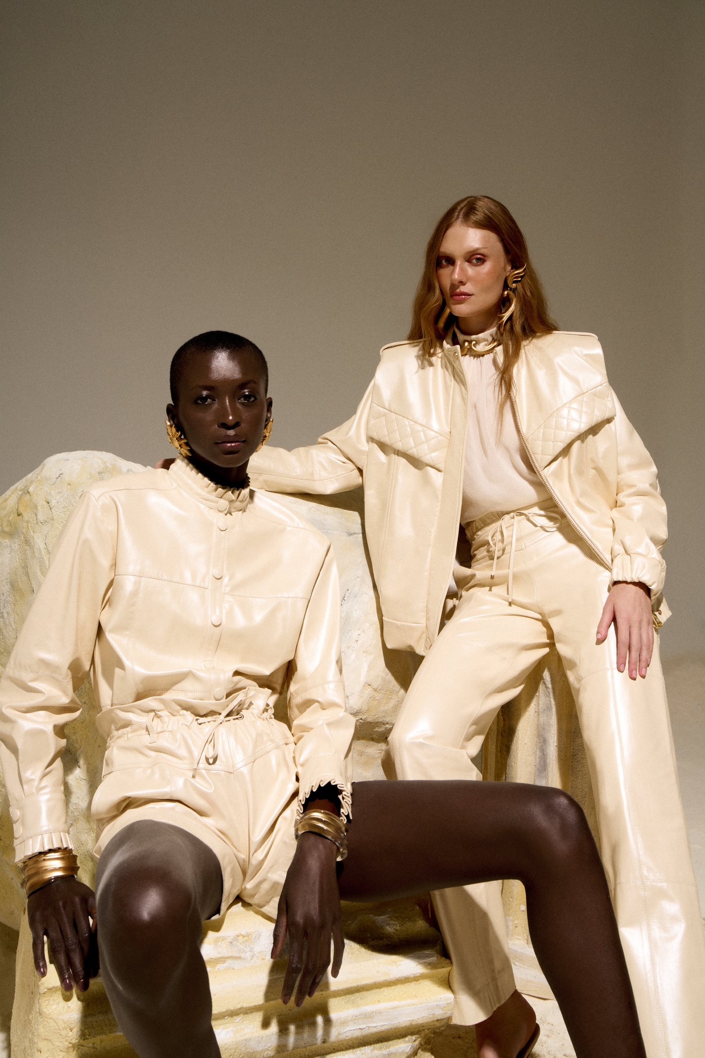 Duas pessoas em roupas bege elegantes, contrastando com a expressão 