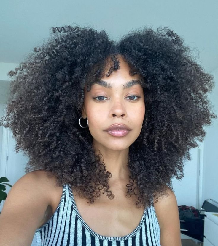 Cabelo crespo volumoso e bem definido, mostrando cuidado ideal com o melhor shampoo para cabelo crespo.