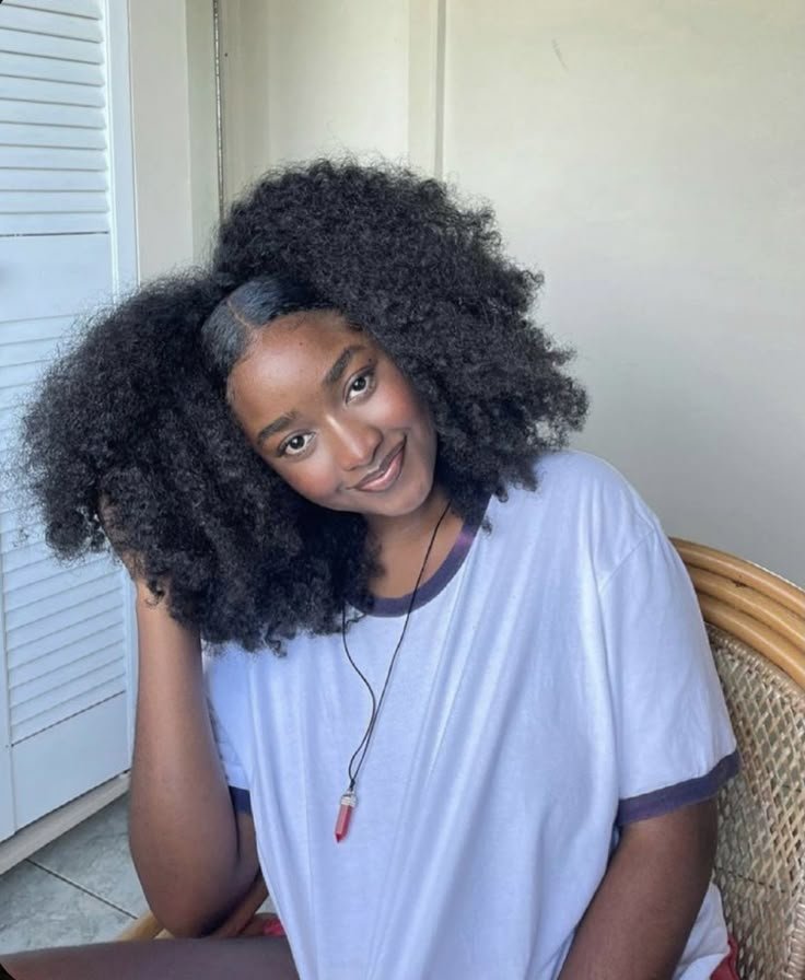 Sorriso de uma pessoa com cabelo crespo volumoso, evidenciando cuidados eficazes com o melhor shampoo para cabelo crespo.