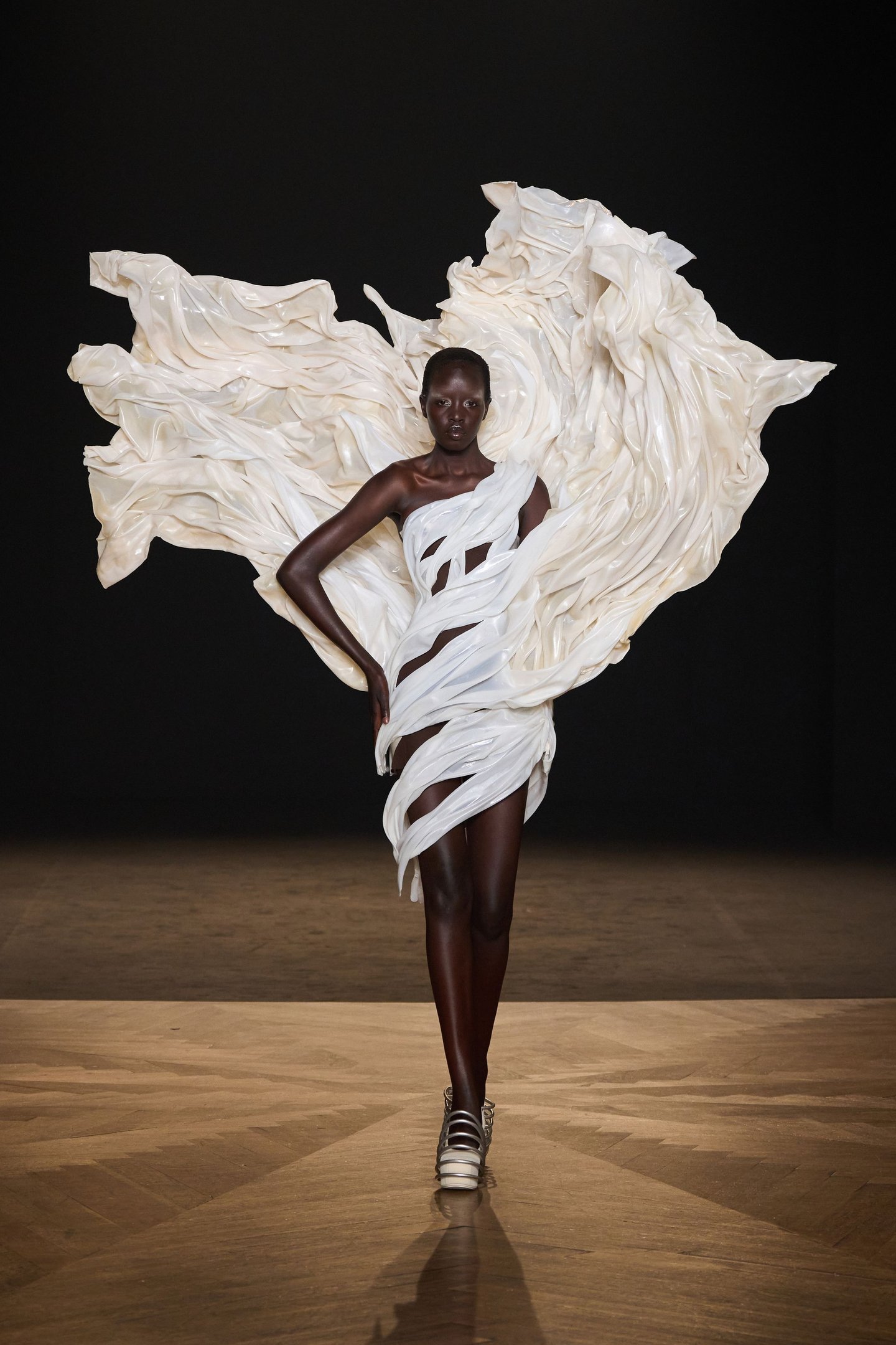 Vestido inovador com drapeados brancos volumosos, destacando as tendências contemporâneas da alta-costura.