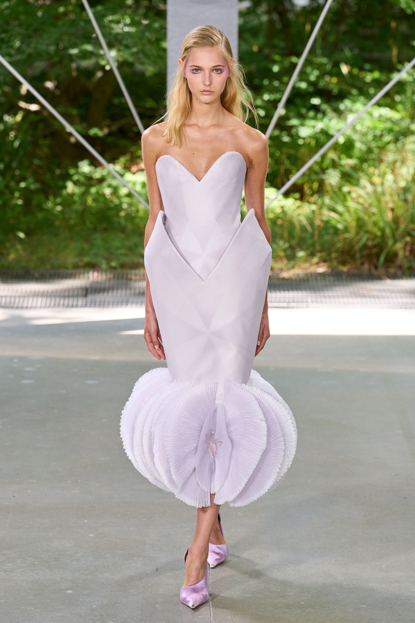 Modelo desfila vestido lilás estruturado com detalhes volumosos no busto e na barra. Tendências da semana de alta-costura.