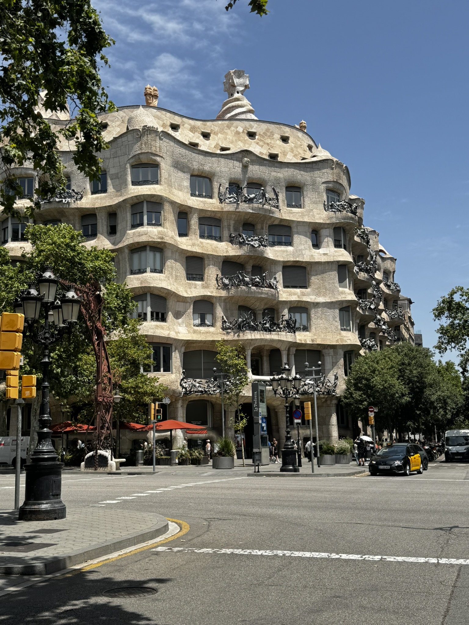 Edifício modernista em Barcelona sob céu azul, atmosfera vibrante do verão europeu.