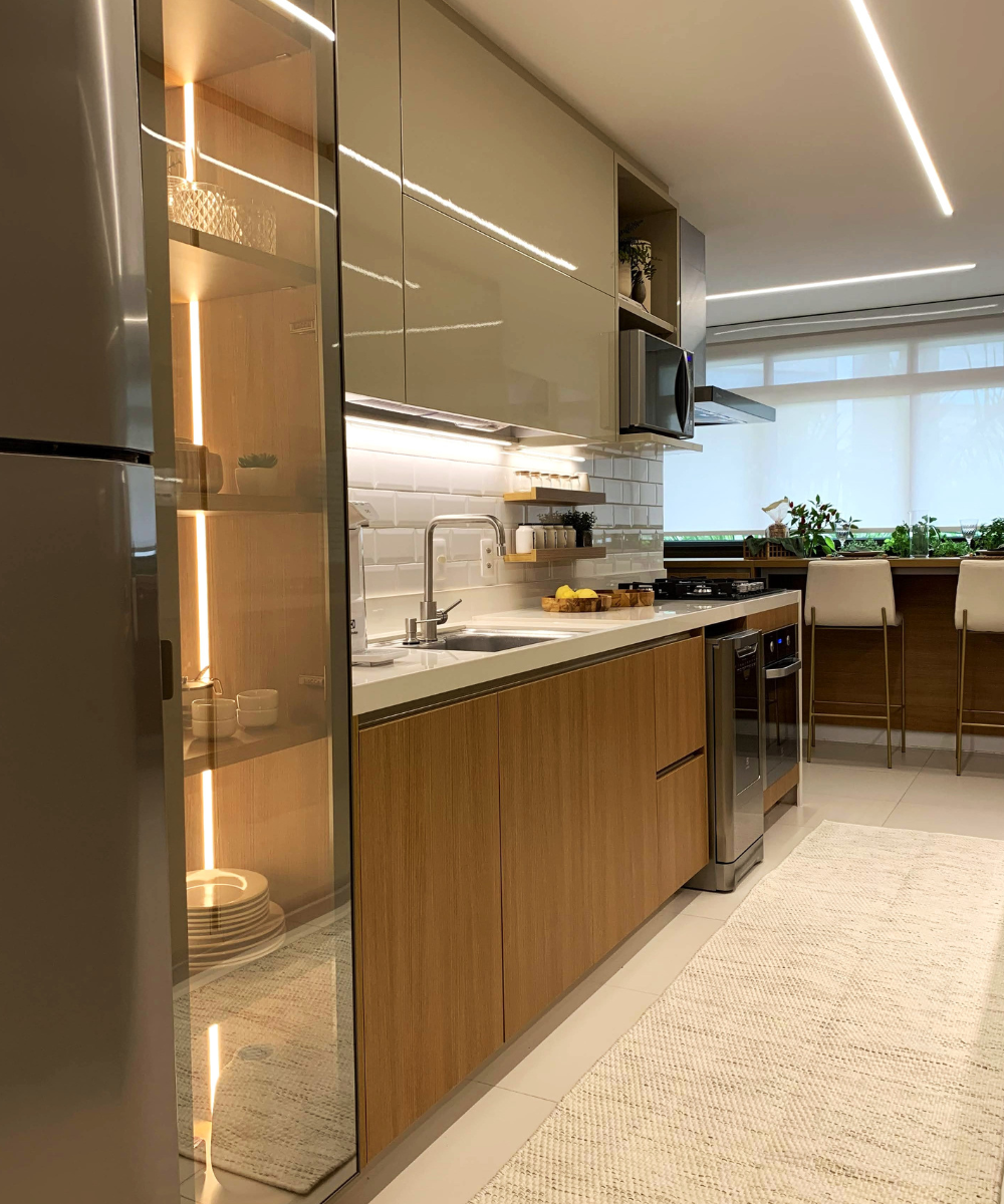Cozinha moderna com móveis de madeira clara, iluminação suave e plantas, promovendo tranquilidade e bem-estar.