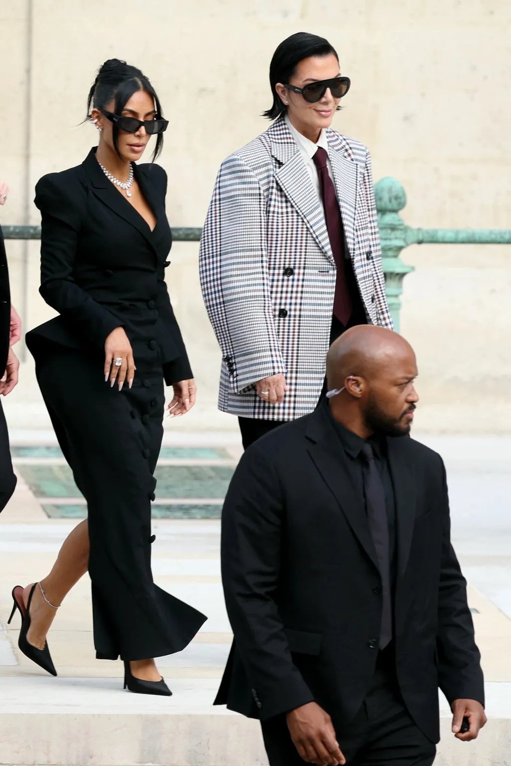 Pessoas elegantes caminham, usando acessórios da moda, como óculos de sol estilosos.