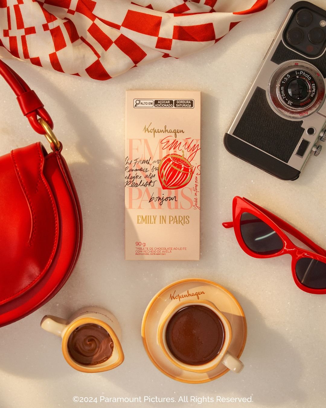 Objetos de cor vermelha ao lado de uma embalagem de chocolate