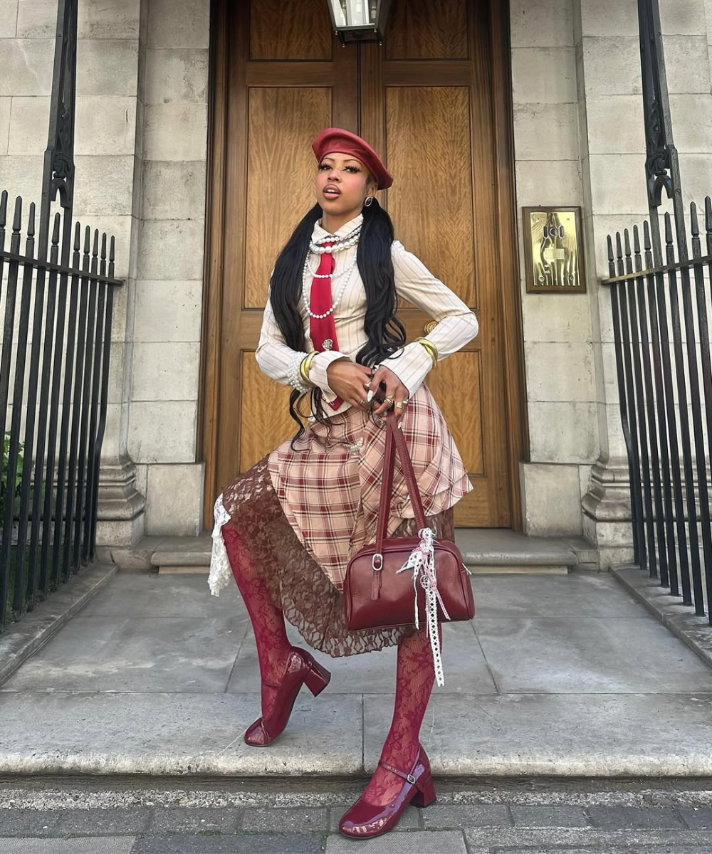 Pessoa posando com roupa elegante em tons de vermelho. Mostra como misturar prata e dourado no look.
