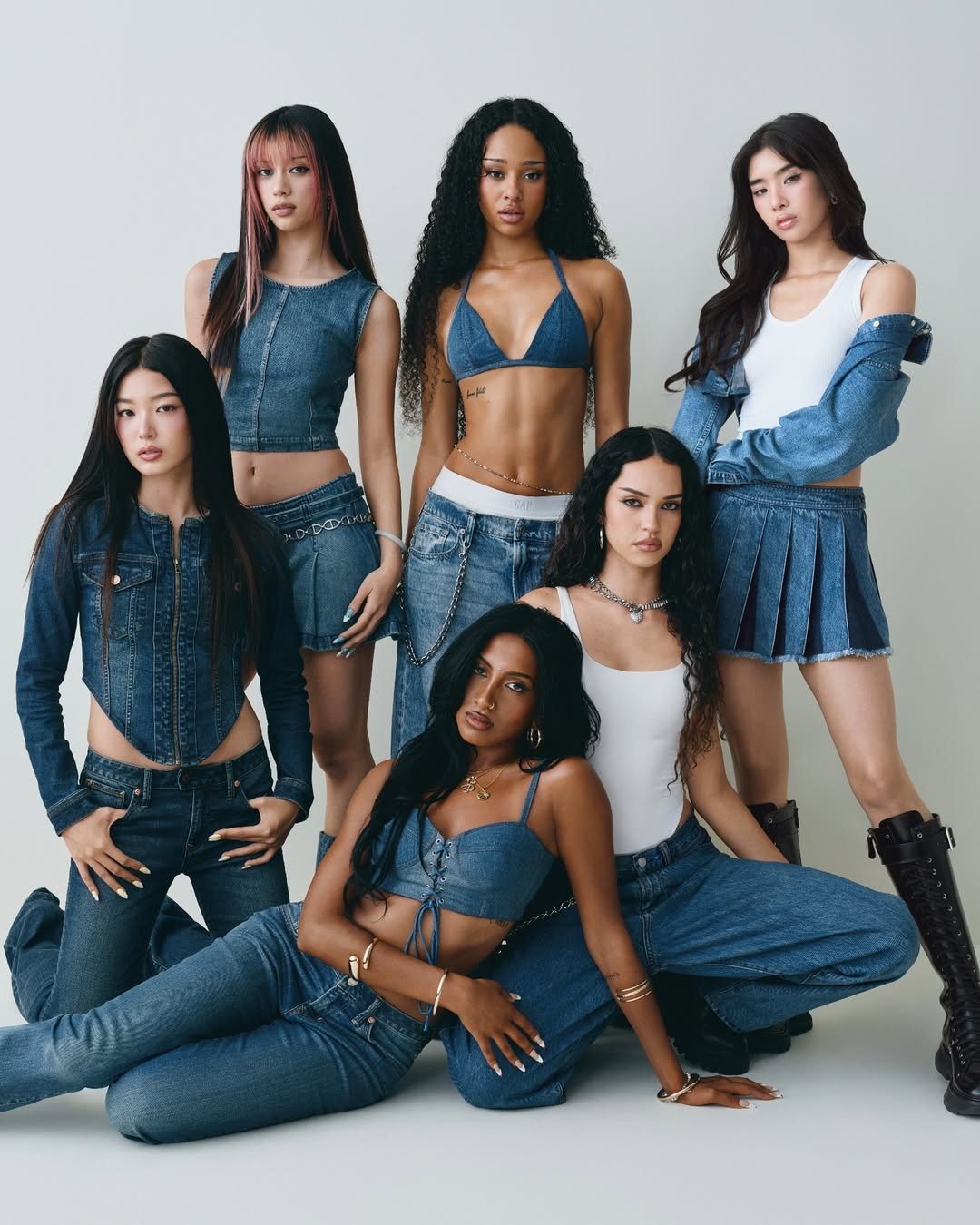 Seis mulheres em roupas jeans variadas posam juntas. Um visual moderno e coordenado. Gap x Katseye