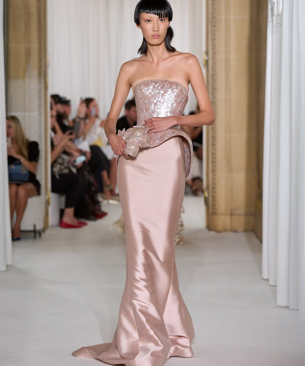 Modelo desfila vestido longo tomara que caia rosa claro com detalhes brilhantes, em evento elegante Schiaparelli.