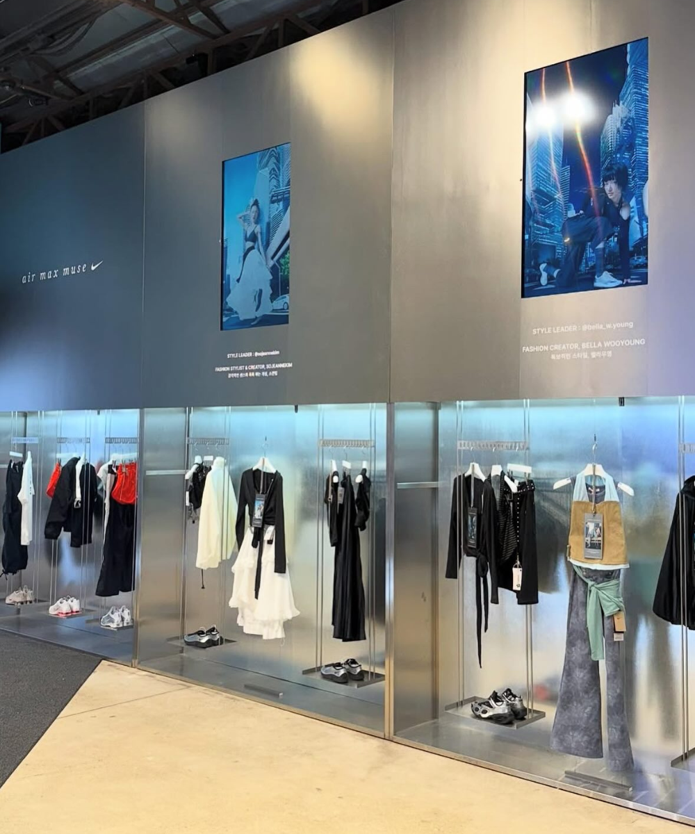 Loja moderna com roupas e tênis exibidos em vitrines. Fotos promocionais adornam a parede. Elementos sugerem estilo asiático.