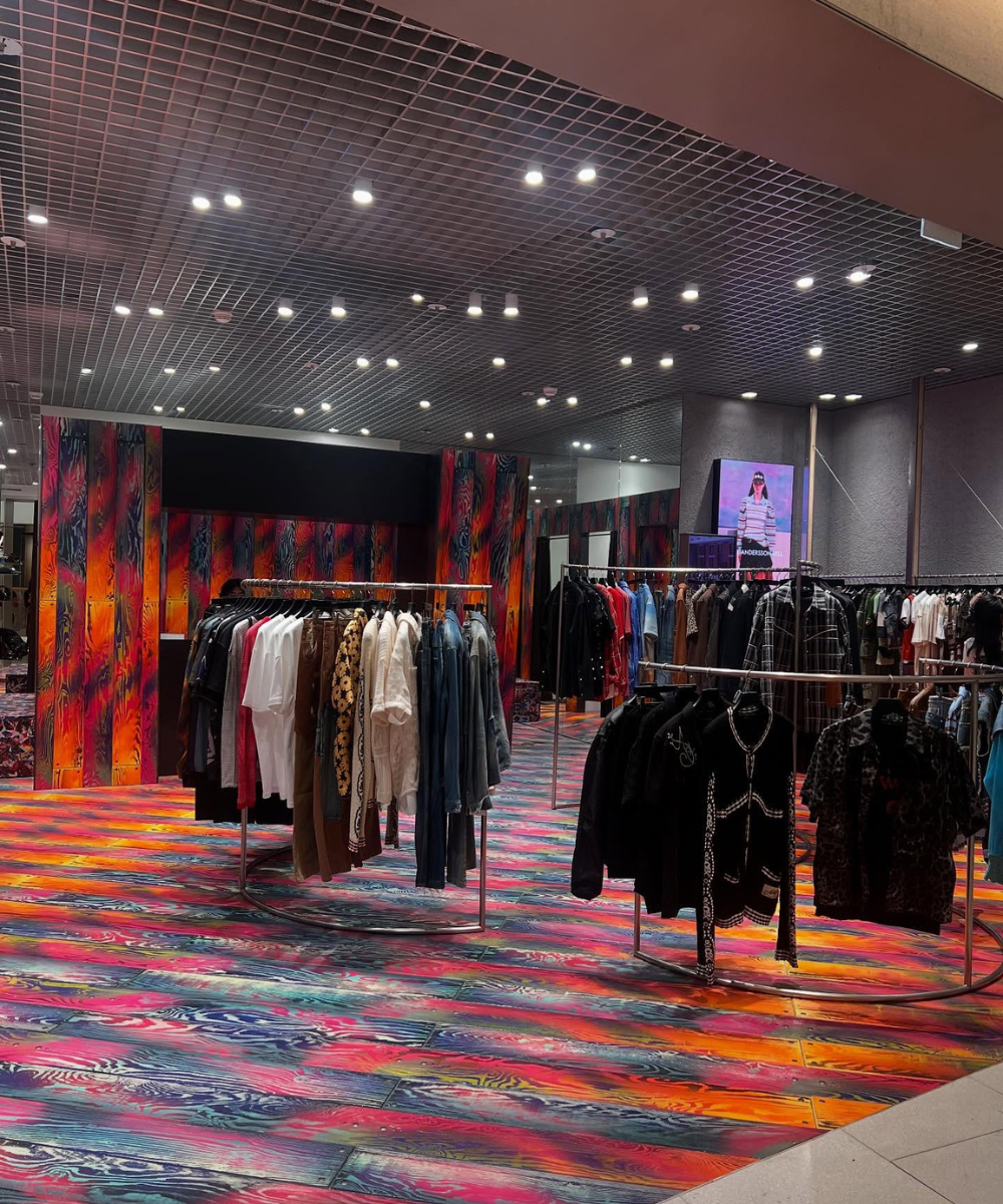 Loja de roupas com decoração colorida com influências asiáticas, exibindo jaquetas e camisetas.