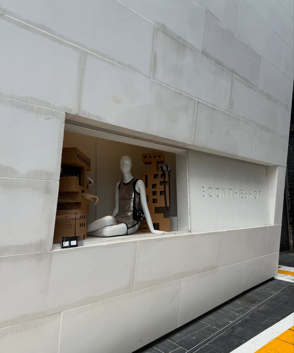 Manequim em vitrine de loja de moda na Ásia, vestido prateado e decoração moderna ao redor.