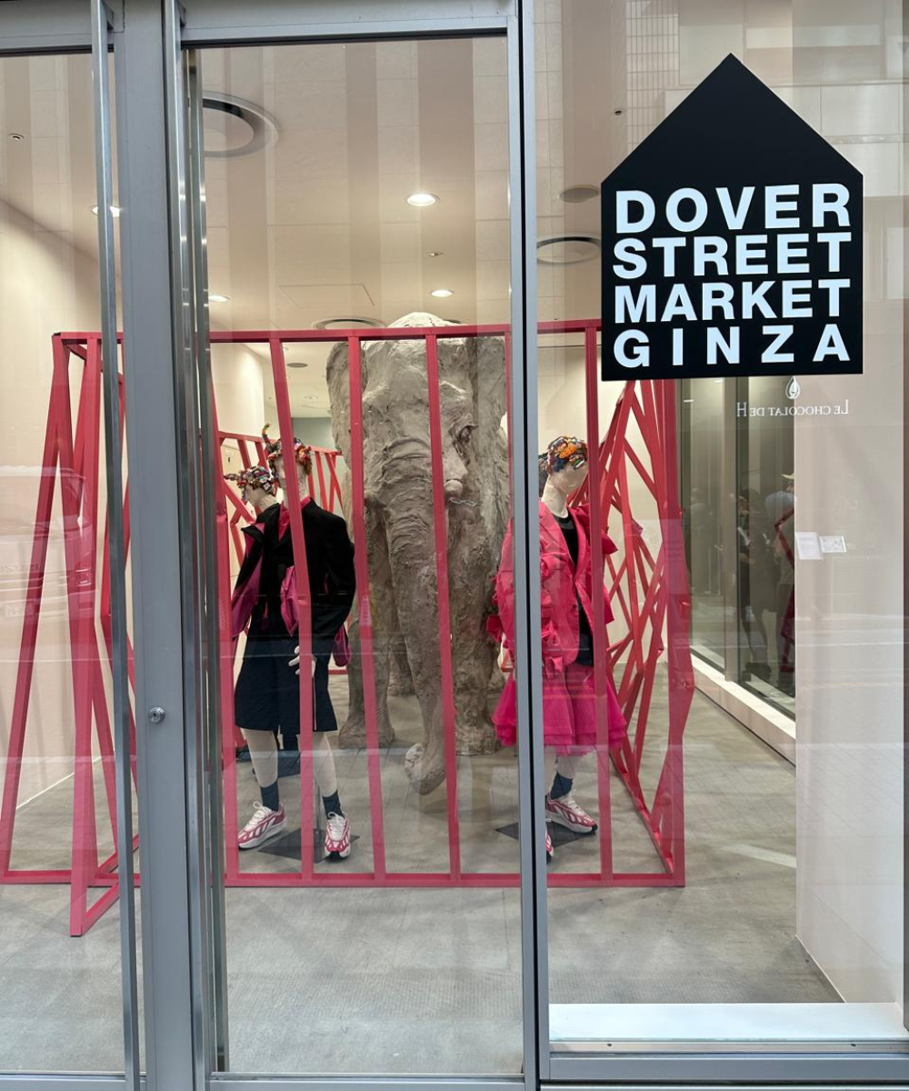 Vitrine da Dover Street Market Ginza com manequins e estrutura artística vermelha, localizada na Ásia.