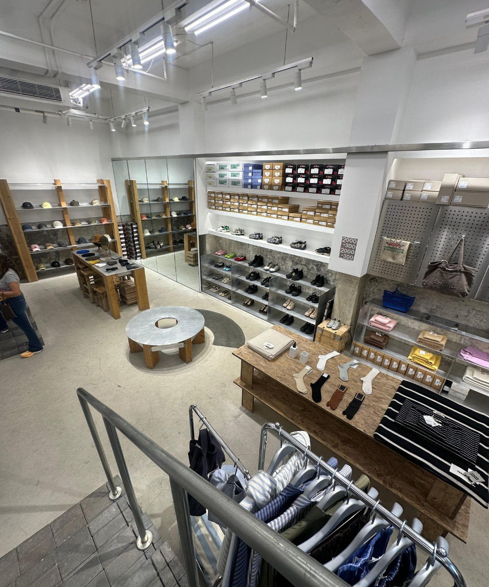 Loja moderna com sapatos e roupas organizados, decoração minimalista e estética inspirada na Ásia.