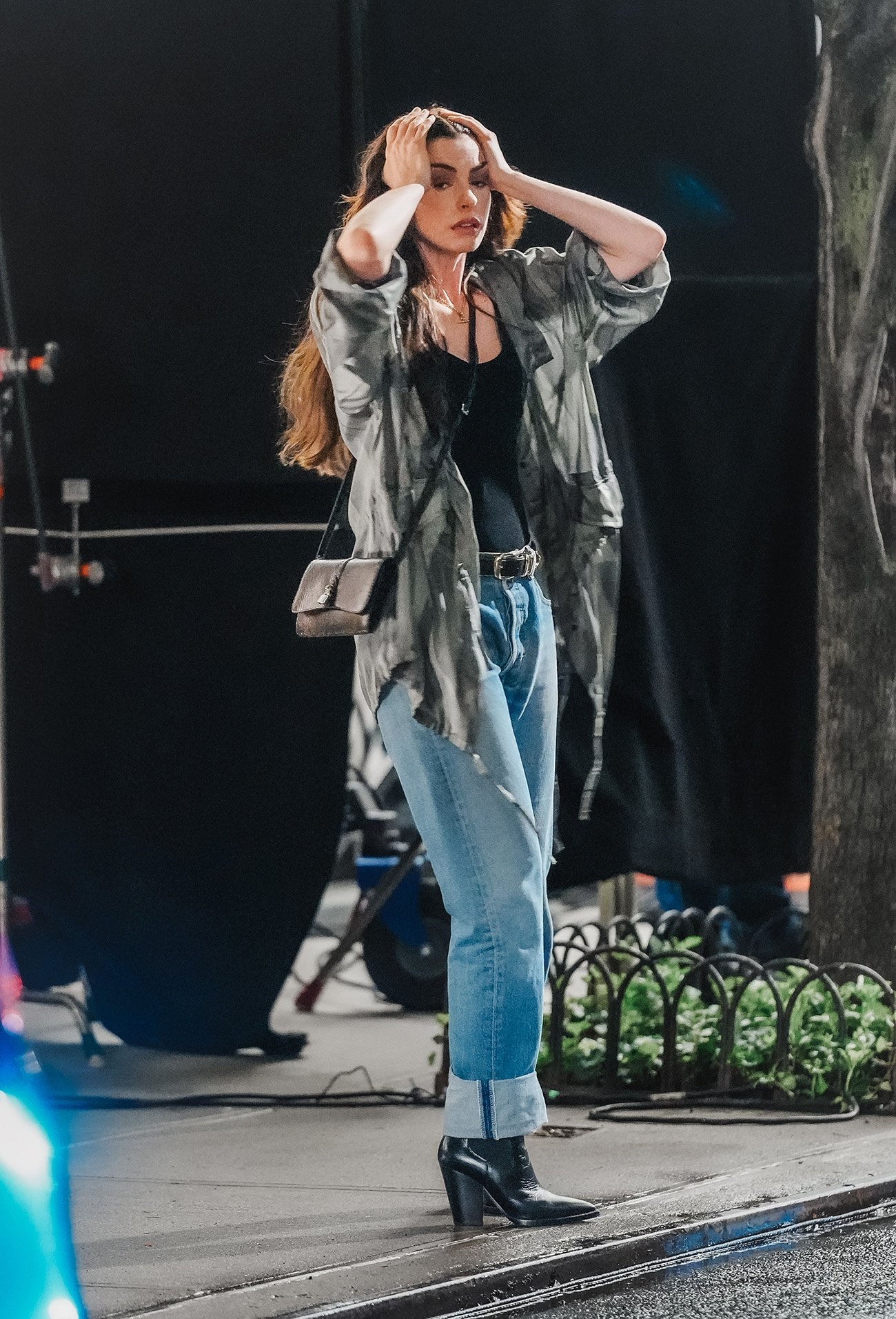 Pessoa com expressão preocupada, mãos na cabeça, vestindo jeans e jaqueta. Filmagem remete a O Diabo Veste Prada 2.