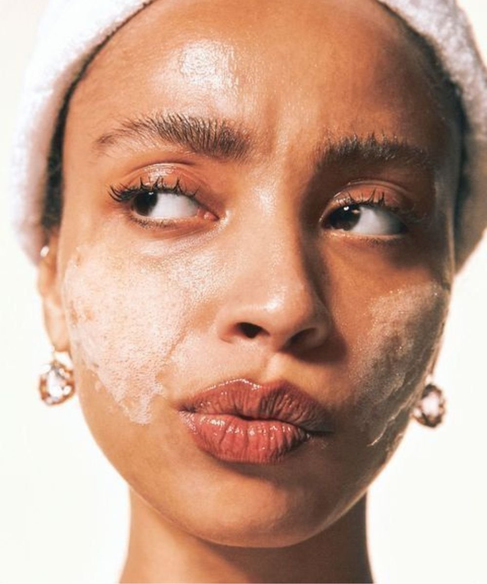 Rosto de mulher com sabonete facial, indicando cuidados com pele oleosa e uso dos melhores produtos para pele oleosa.