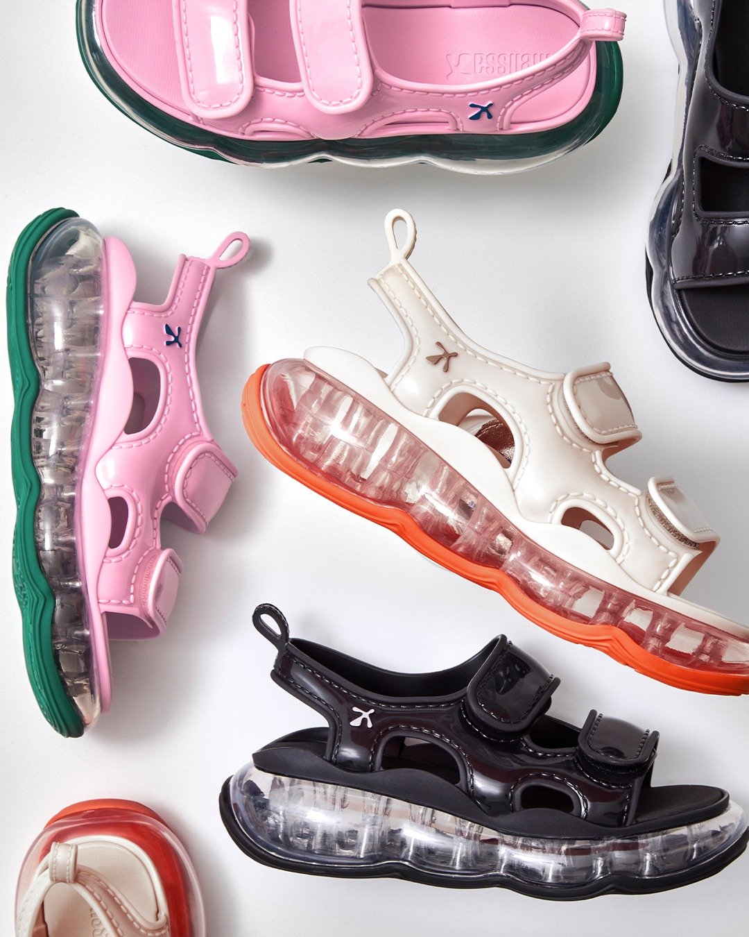 Sandálias coloridas Melissa com solado transparente e fechamento em velcro, em estilo moderno e chamativo.